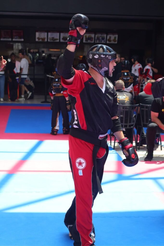 JR Lopez raising his fist on the mat at a sport karate tournament